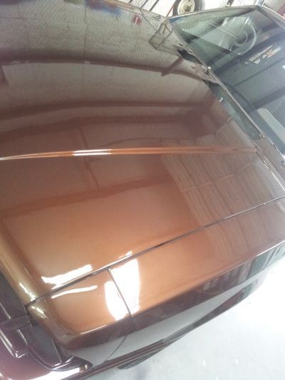 A car is parked in a garage with the hood up