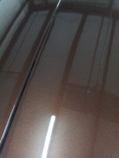 A close up of the hood of a brown car