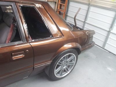 A brown car with a broken window is parked in a garage