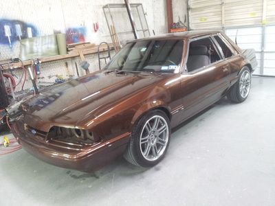 A brown car is parked in a garage next to a garage door