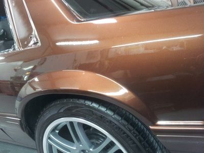 A close up of a brown car with silver wheels