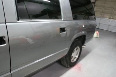 A silver suv is parked in a garage next to a garage door