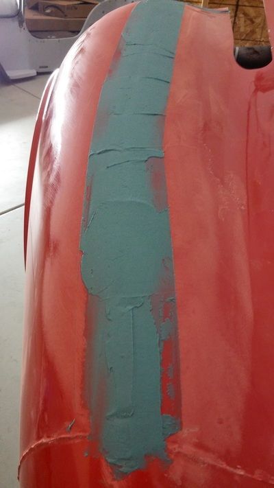 A close up of a red pumpkin with blue tape on it