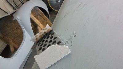 A piece of paper is laying on a table next to a piece of metal