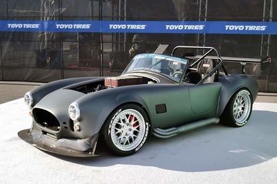 A toyo tires car is parked in front of a building