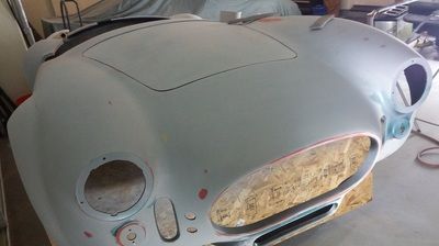 A white car hood is sitting on top of a wooden table