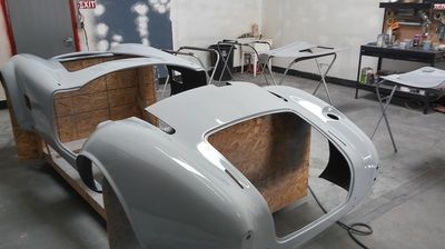 A white car is being built in a garage