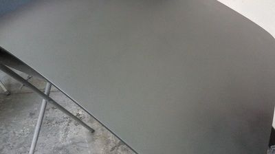 A close up of a gray table top on a concrete floor