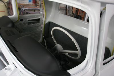 The inside of a white car with a white steering wheel