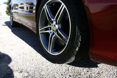 A close up of a car wheel on a gravel road