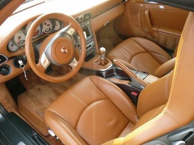 The interior of a car with brown leather seats and a steering wheel