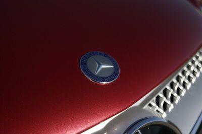 A close up of the hood of a red mercedes benz
