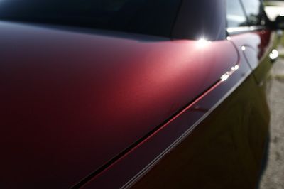 A red car is parked on the side of the road