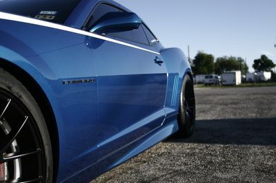 A blue car is parked on the side of the road