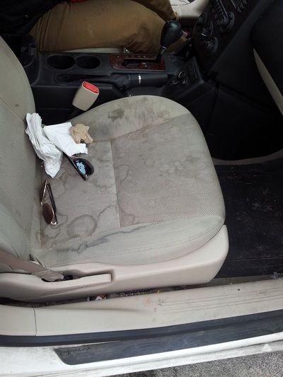 A dirty car seat with a pair of keys on it
