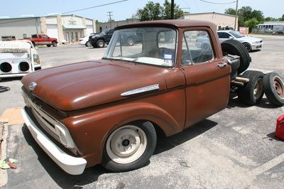 An old brown truck is parked in a parking lot