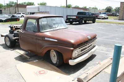 A brown ford truck is parked in a parking lot
