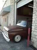 A brown truck is parked in front of a garage door