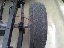 A close up of a tire on a vehicle frame