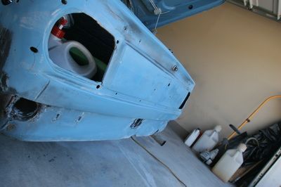 A blue car is sitting on the ground in a garage