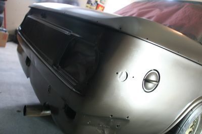 A car is sitting in a garage with the trunk open