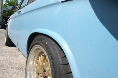 A close up of a blue car with gold wheel