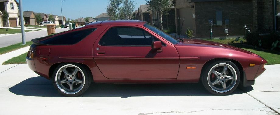 A red sports car is parked on the side of the road