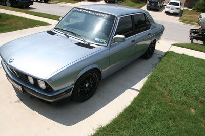 A silver bmw is parked on the side of the road