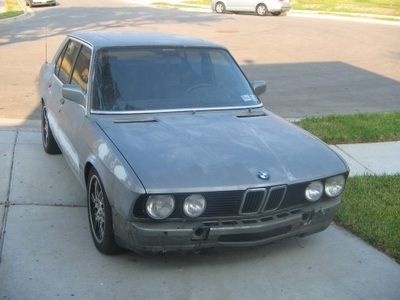 A gray bmw is parked on the side of the road
