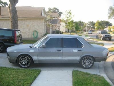 A silver car is parked on the side of the road