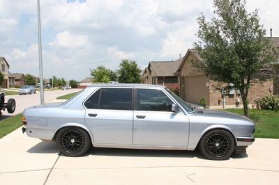 A silver car is parked in a driveway in front of a house