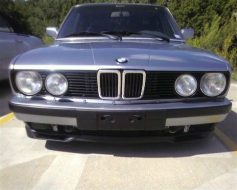 A silver bmw is parked in a parking lot