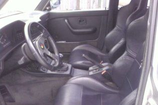 The inside of a car with black seats and a steering wheel