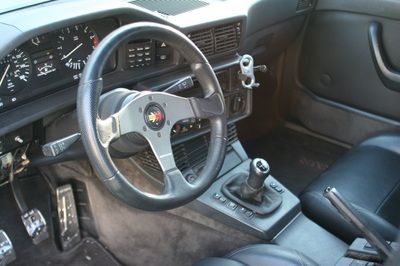 The inside of a car with a steering wheel and dashboard