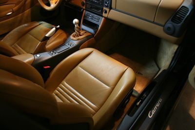 The interior of a porsche carrera with tan leather seats