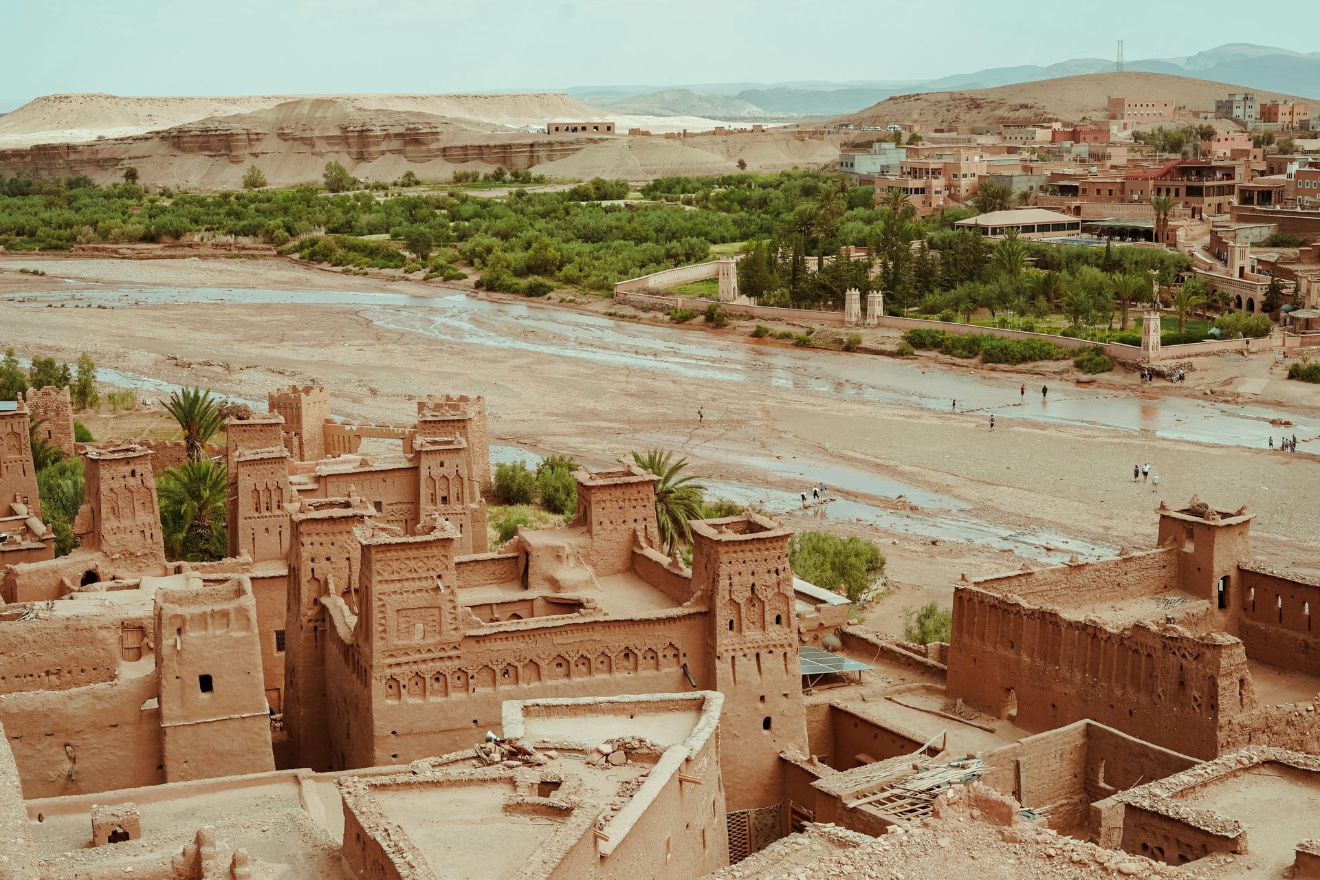 An aerial view of a desert village with a river running through it.
