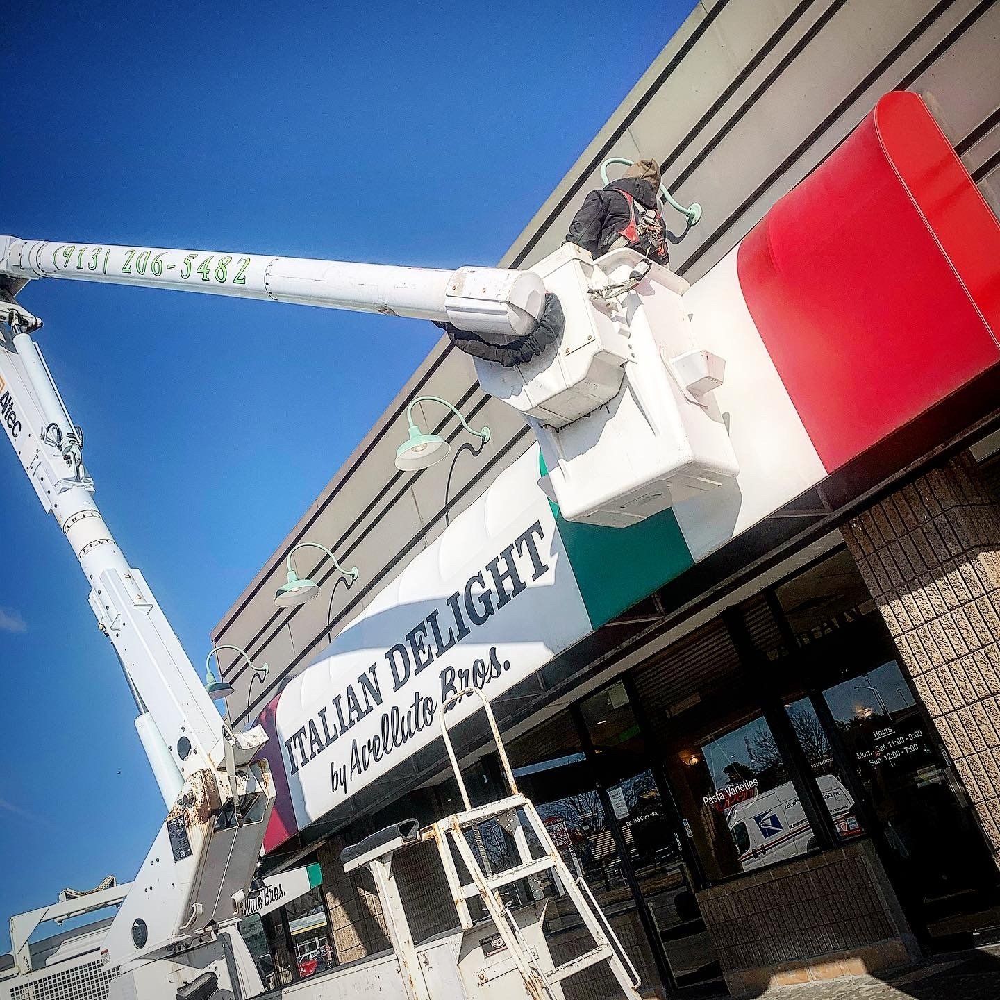A crane is working on a sign for italian delight