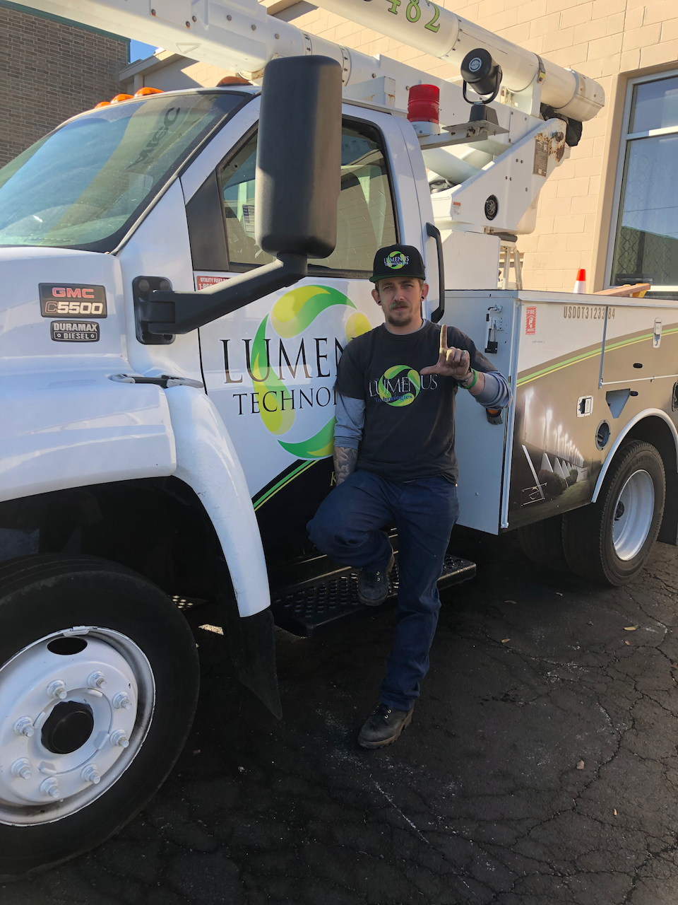 A man is standing in front of a truck that says lume tic inc.