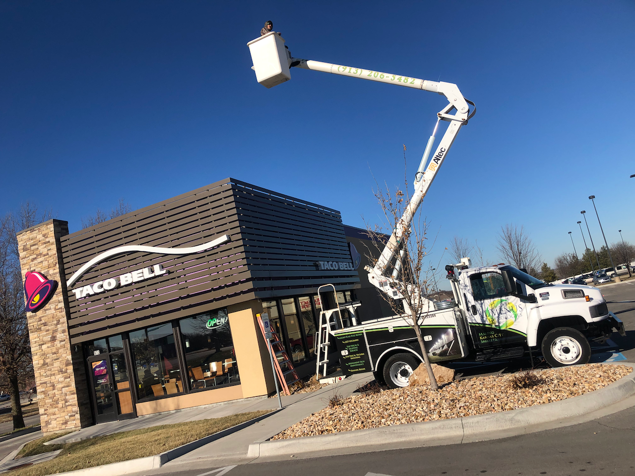 A white truck is parked in front of a taco bell restaurant.