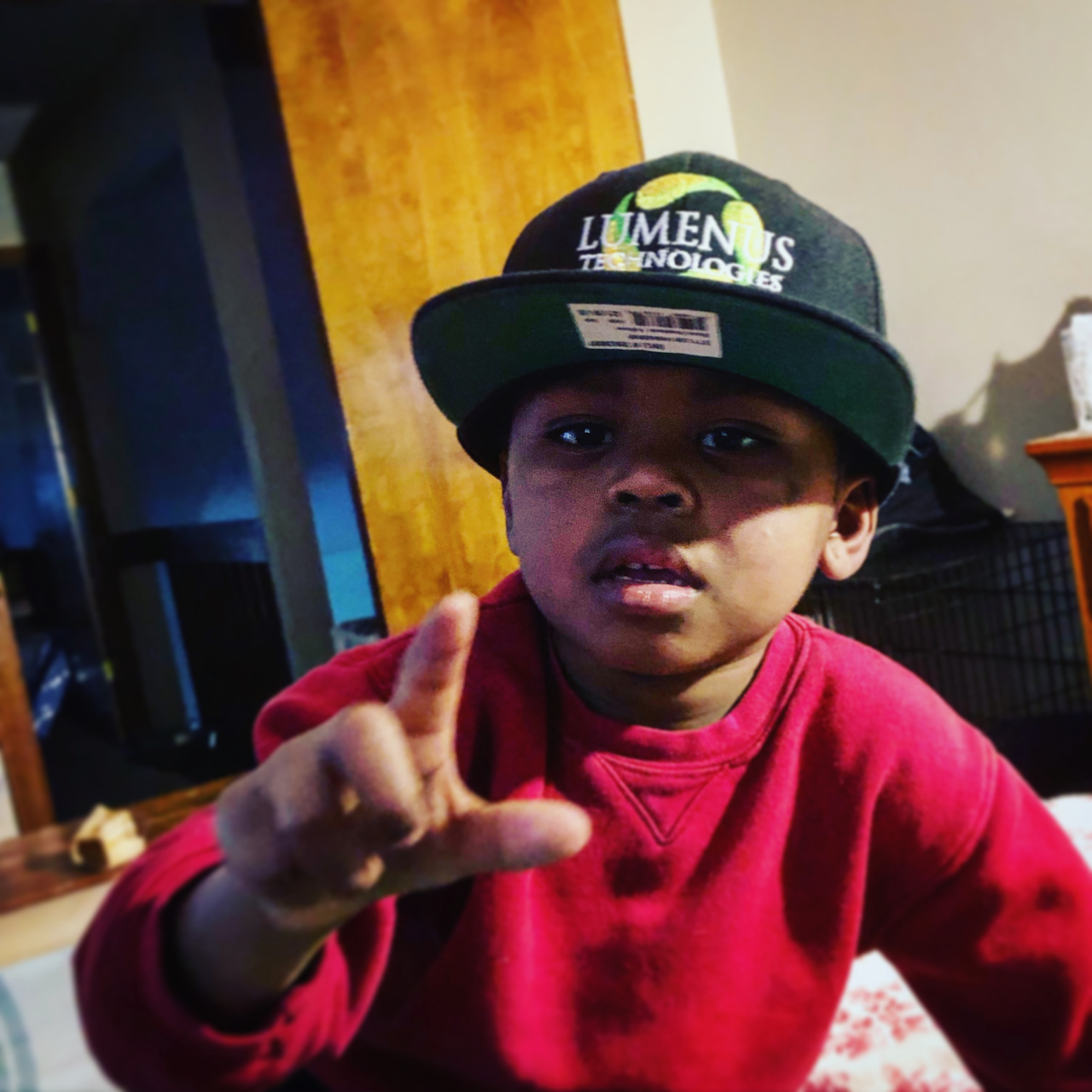 A young boy wearing a hat that says lumens technology