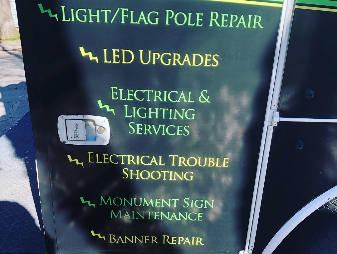 A sign that says light / flag pole repair on it
