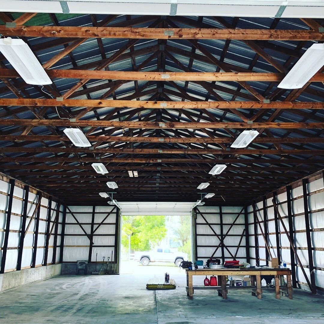 The inside of a building with a wooden roof and a large door.