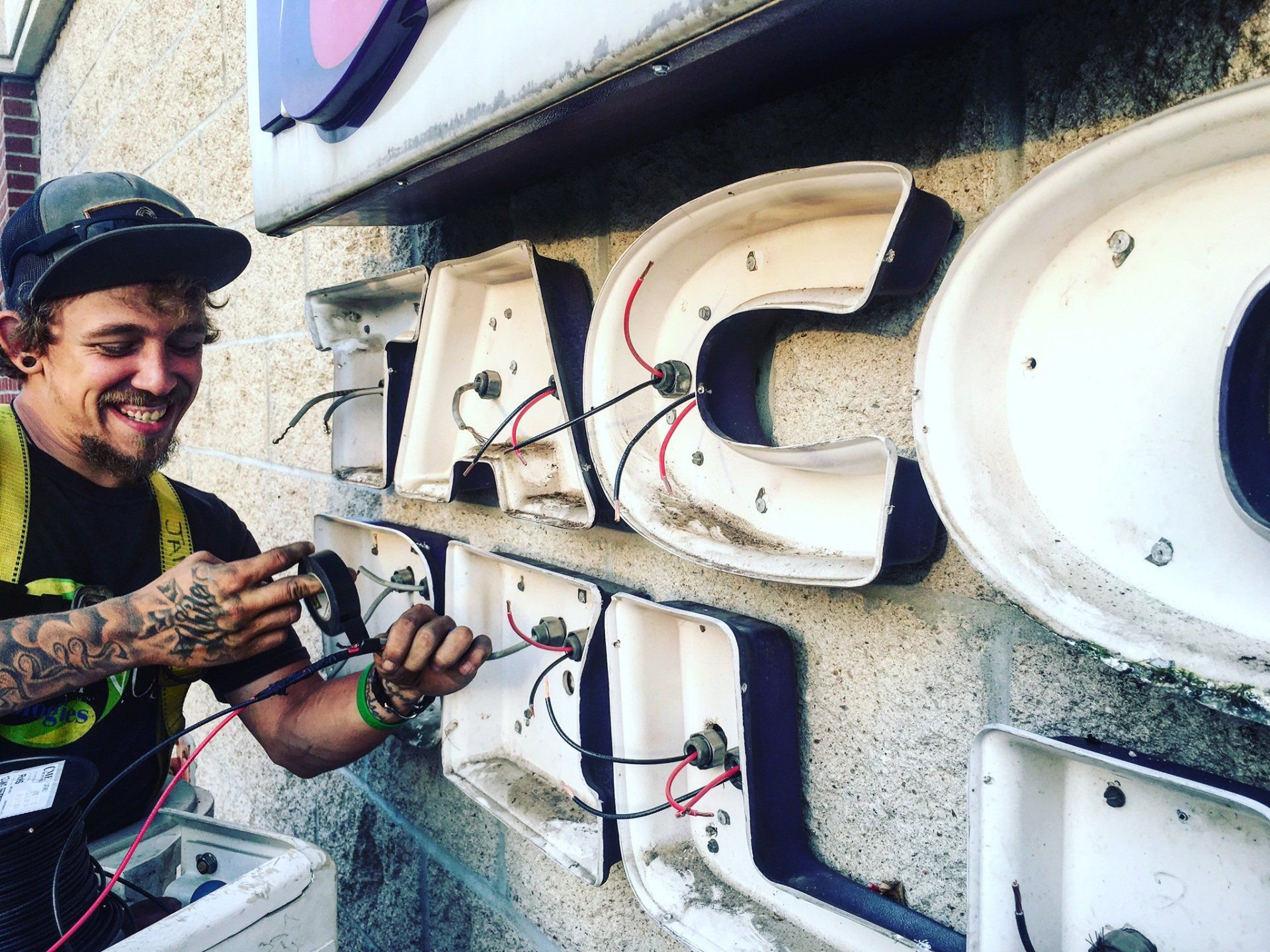 A man is working on a sign that says taco