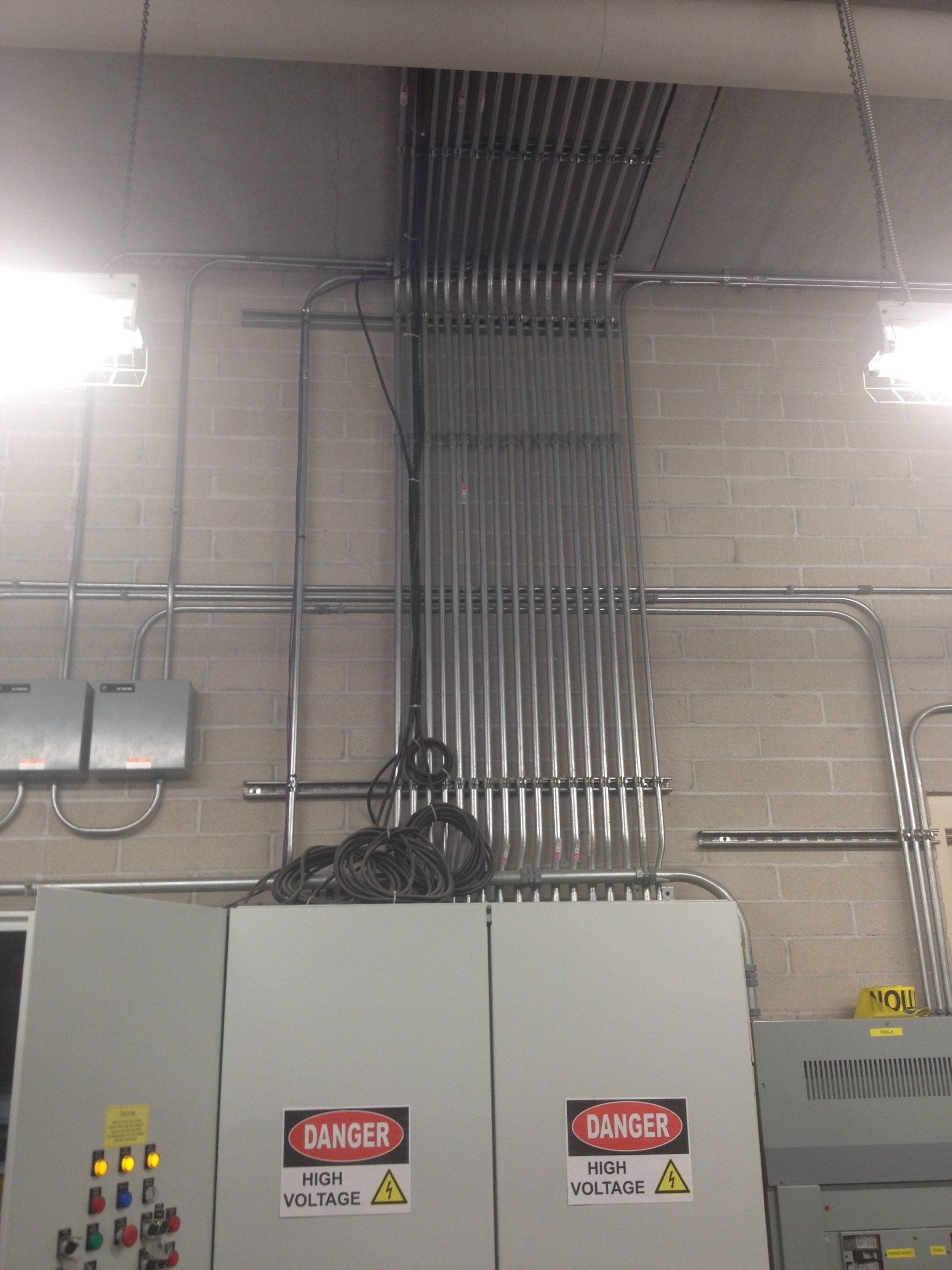 A room with a lot of electrical wires hanging from the ceiling.