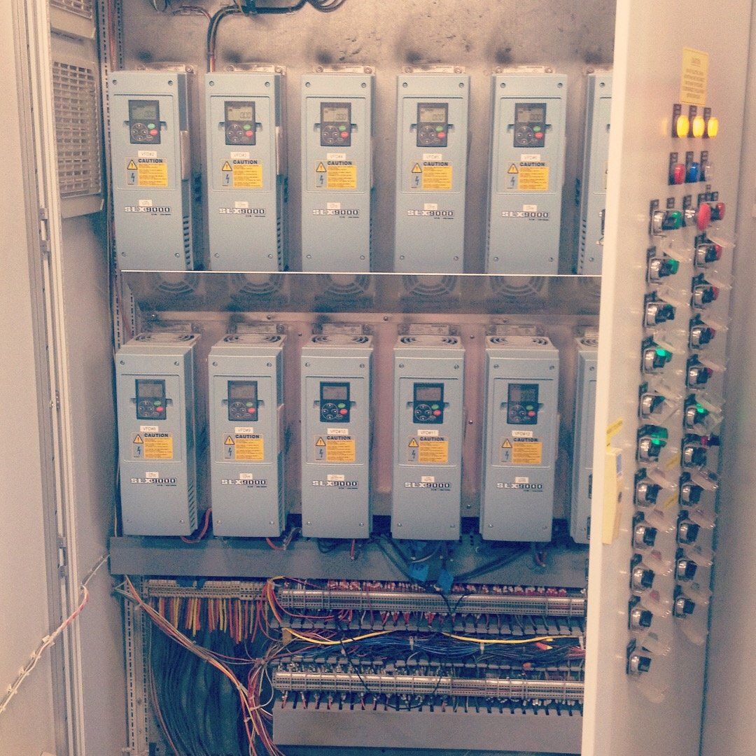 A bunch of electrical boxes are lined up in a room.