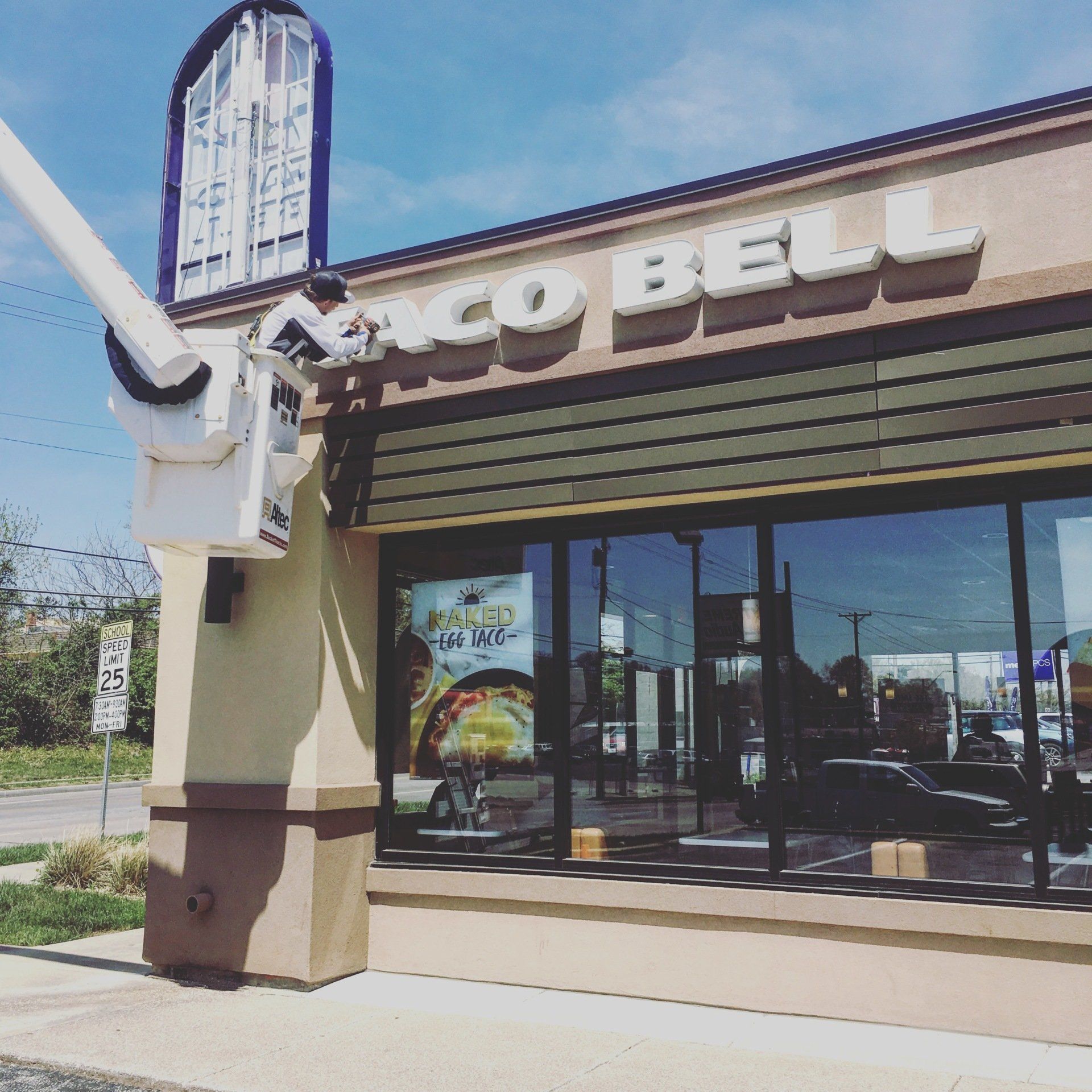 A taco bell restaurant with a crane in front of it