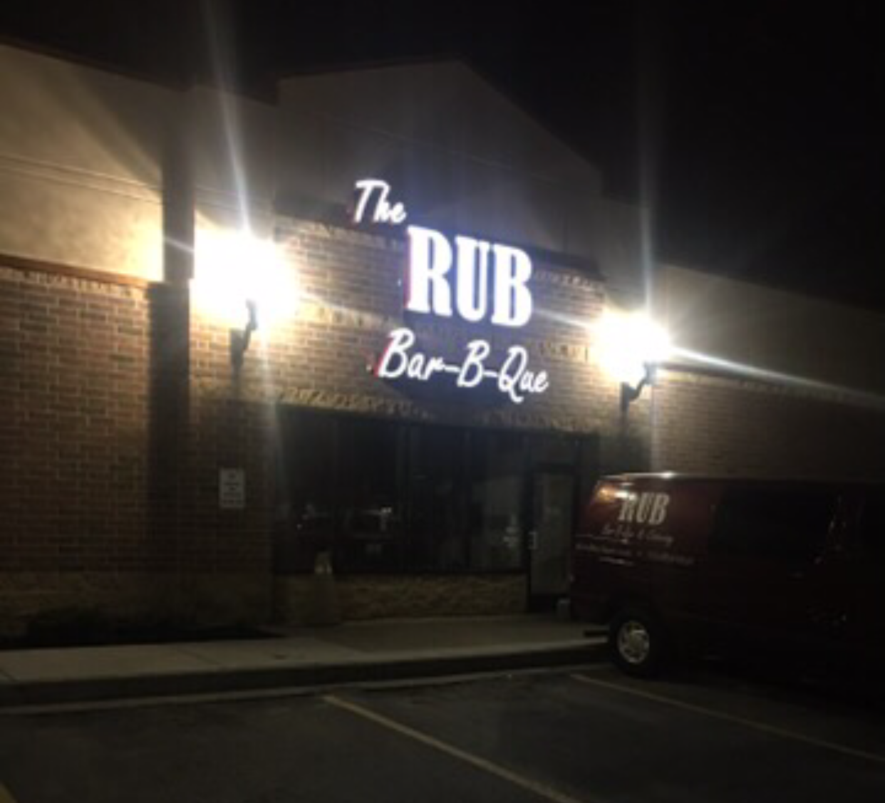 A restaurant called the rub is lit up at night