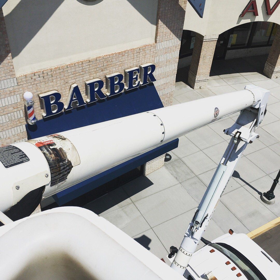 An aerial view of a barber shop with a crane in front of it