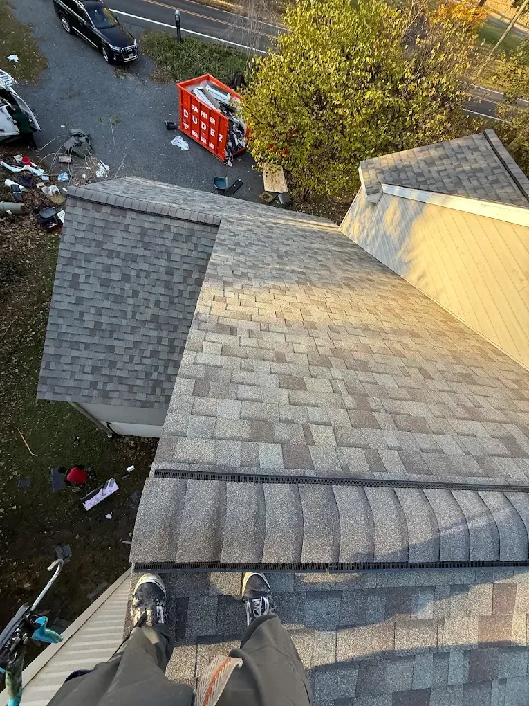 View from a roof over a driveway, with a red pickup truck and autumn trees below.