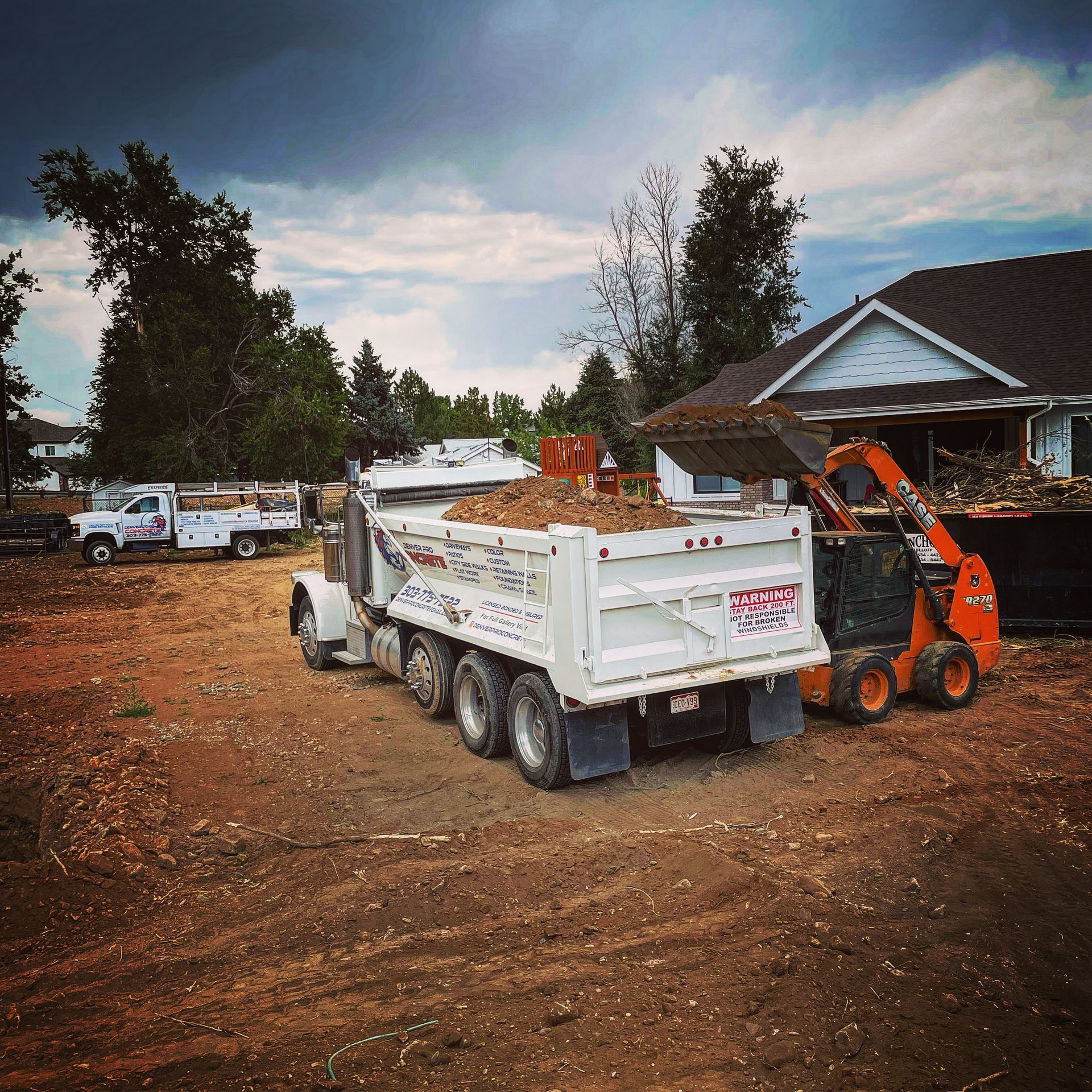 A dump truck is parked in front of a house